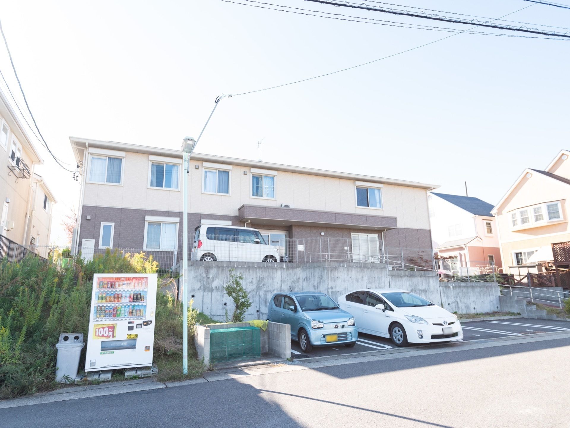 少し坂を上がったところに立っている優しい色合いの２階建ての施設