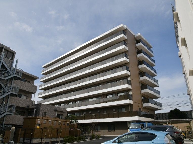 大きなマンションのような外観。各フロアにベランダが付き、駐車場もある。