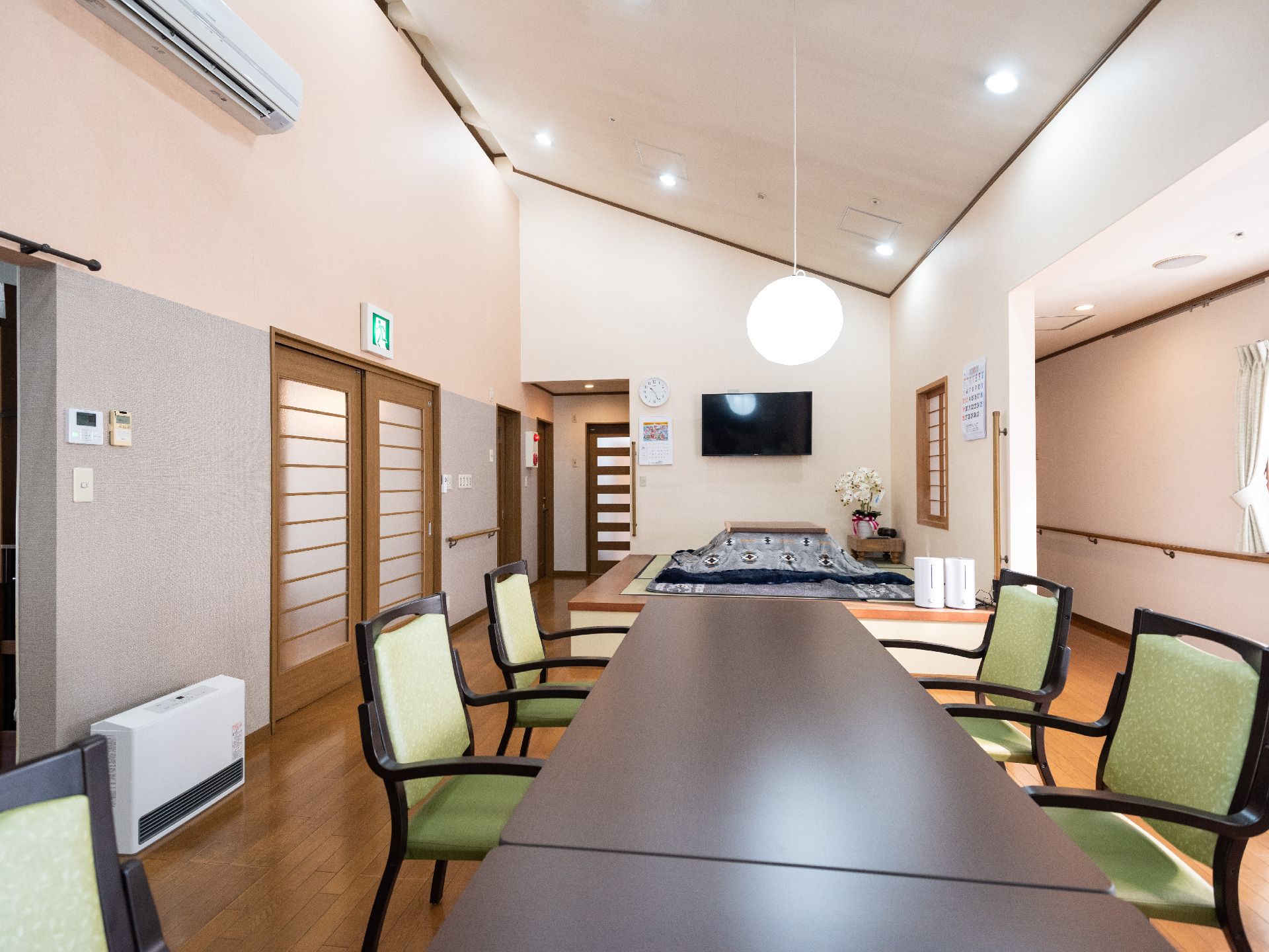 木製のテーブルが並び、部屋の隅に小上がり和室がある落ち着いた雰囲気の食堂