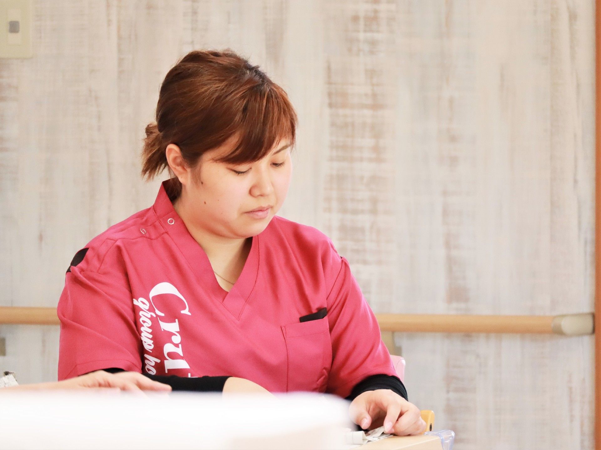 建物内で仕事をしているスタッフ。誰かに目線を合わせ、会話しようとしている。