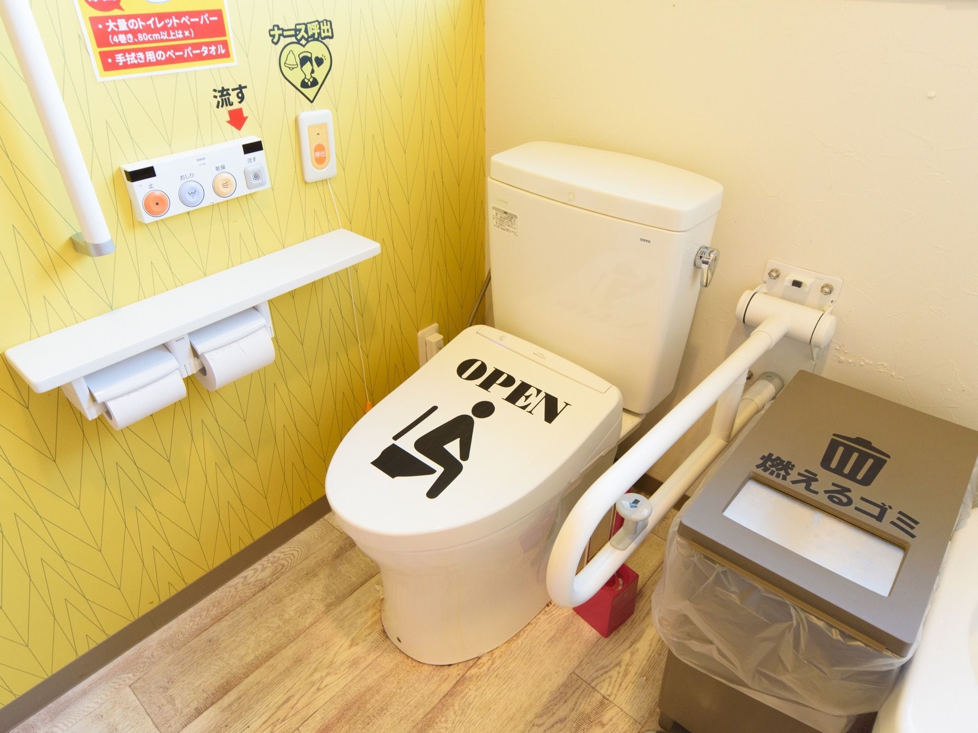 温水洗浄機能付の便器が１台設置されており、便座の右側にゴミ箱が置かれている。壁には手すりやナースコールがある。