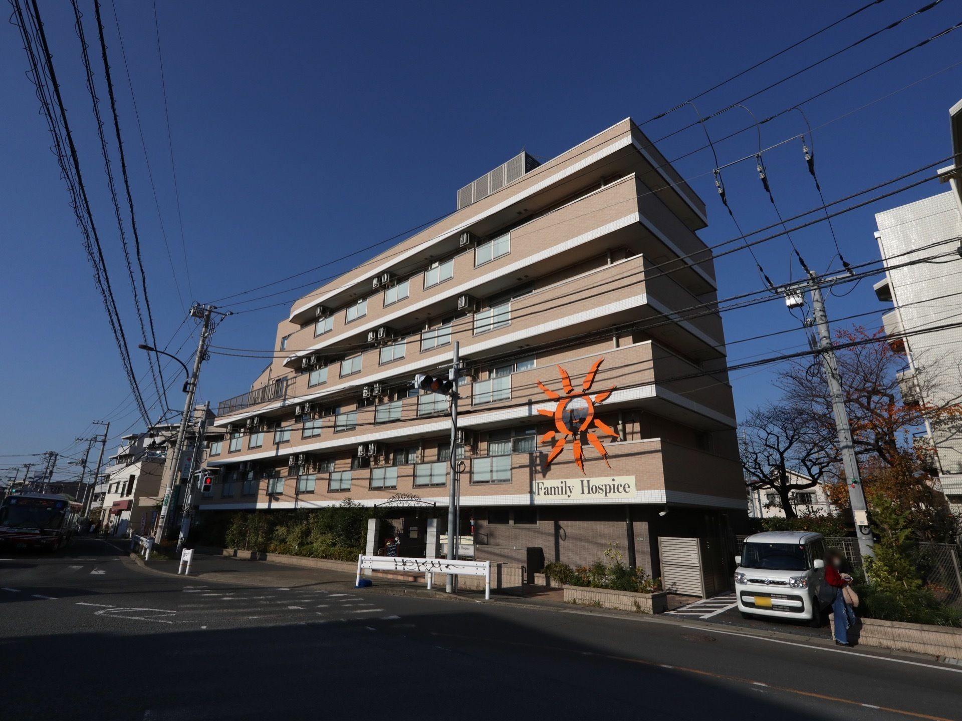 茶色に塗られた建物で、2～4階までベランダが付けられている居室の窓の前の壁は、半透明の板が設置されている。