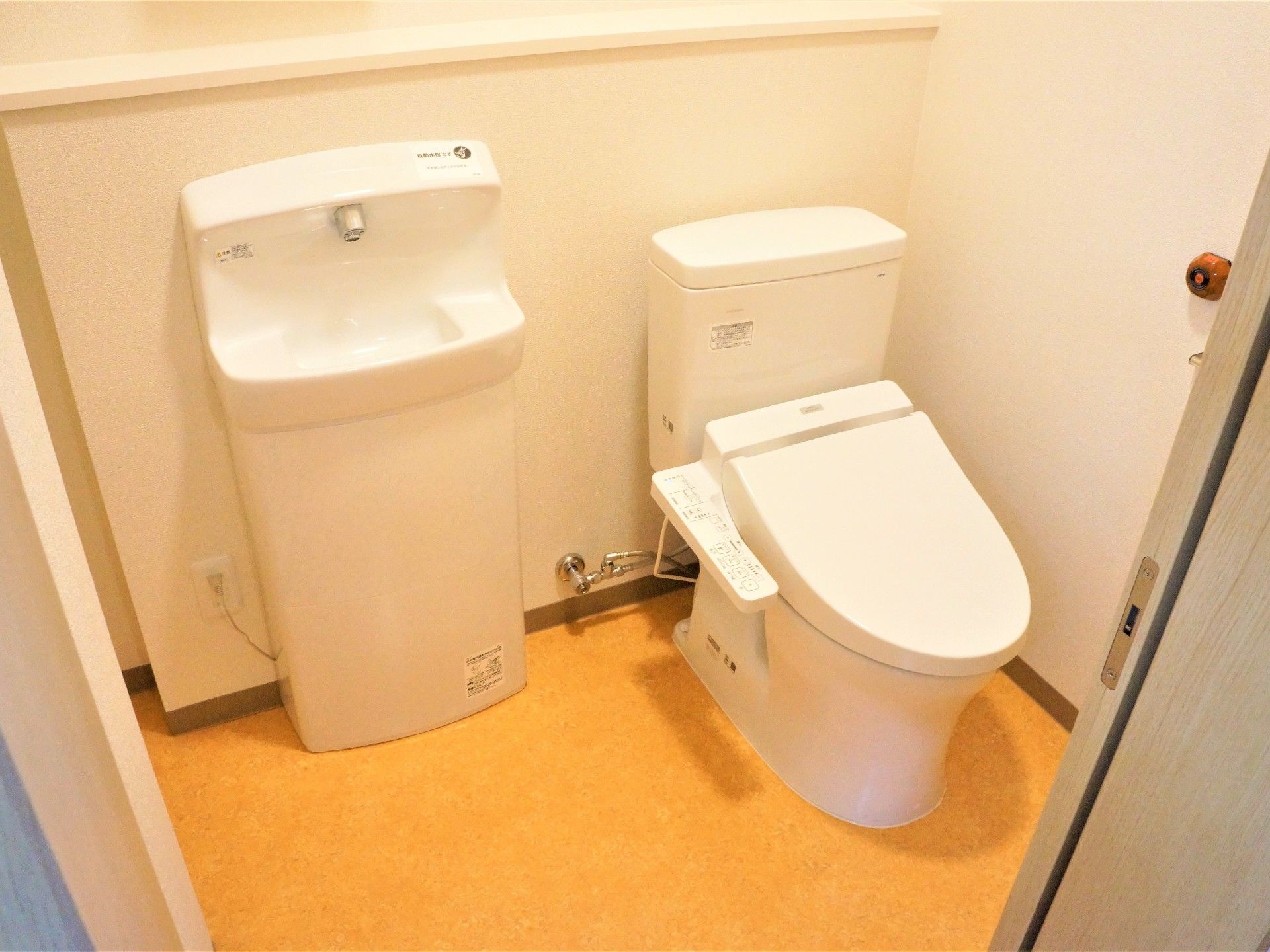 トイレと手洗いが並んで設置されていて、ドアは引き戸。操作ボタンは便座横についている。