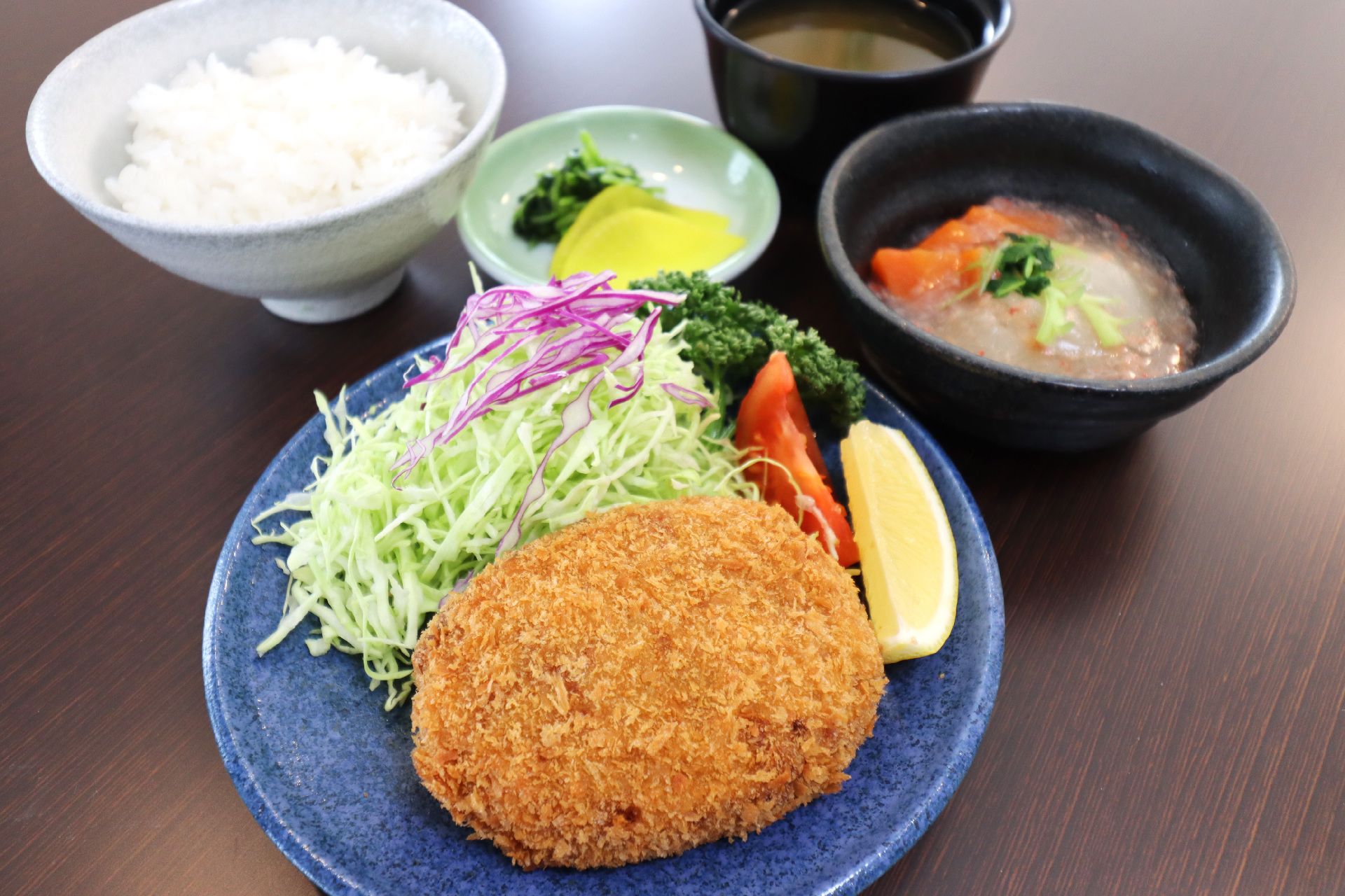 千切りキャベツを添えたコロッケにご飯と味噌汁がセットになったメニュー
