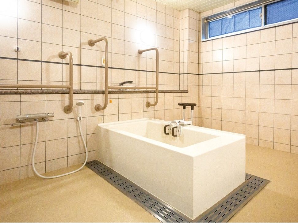 ３方向から介助が可能な個浴が設置された浴室には手すりも多く、洗い場が広い。
