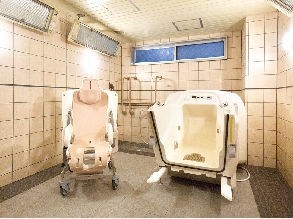 機械浴が完備され、介護度が高い人にも対応しているタイル張りの浴室。壁には窓とパネルヒーターが付いている。