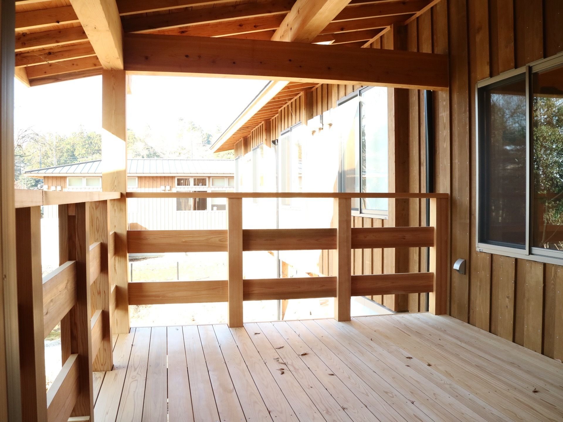 屋根付きのウッドデッキが建物に隣接して造られている。気軽に外気に触れて、施設周りの景色を楽しむことができる。