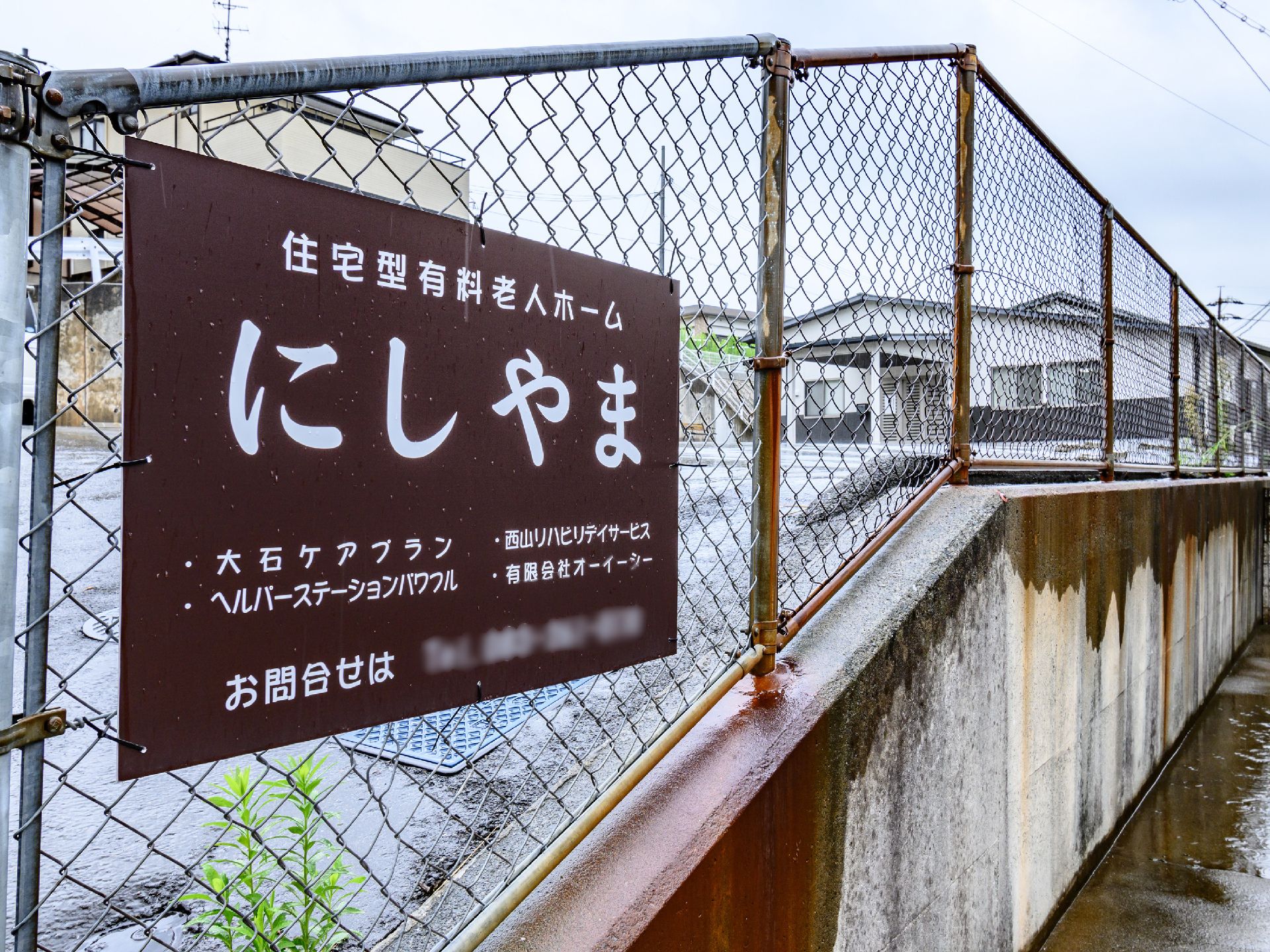 手を振る車椅子に乗った高齢女性と介助をする男性ヘルパー