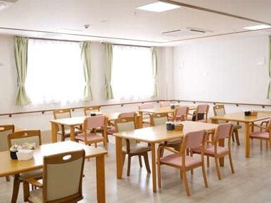 木製のダイニングテーブルがいくつも置かれ、ぬくもりが感じられる明るい食堂。