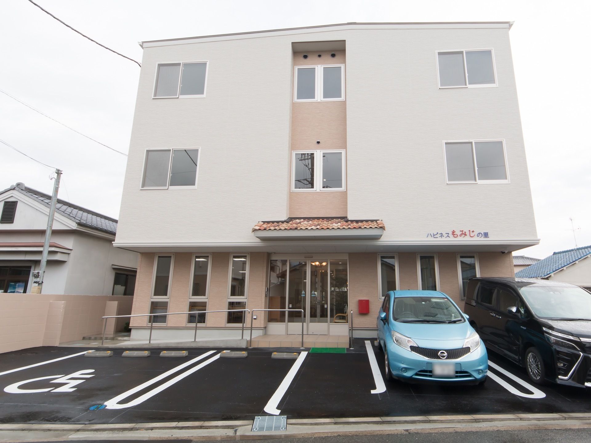 ３階建て鉄骨造の建物で、外壁は２色のクリーム色である。１階のひさしに施設名が掲げられている。玄関ポーチにはスロープと手すりがある。