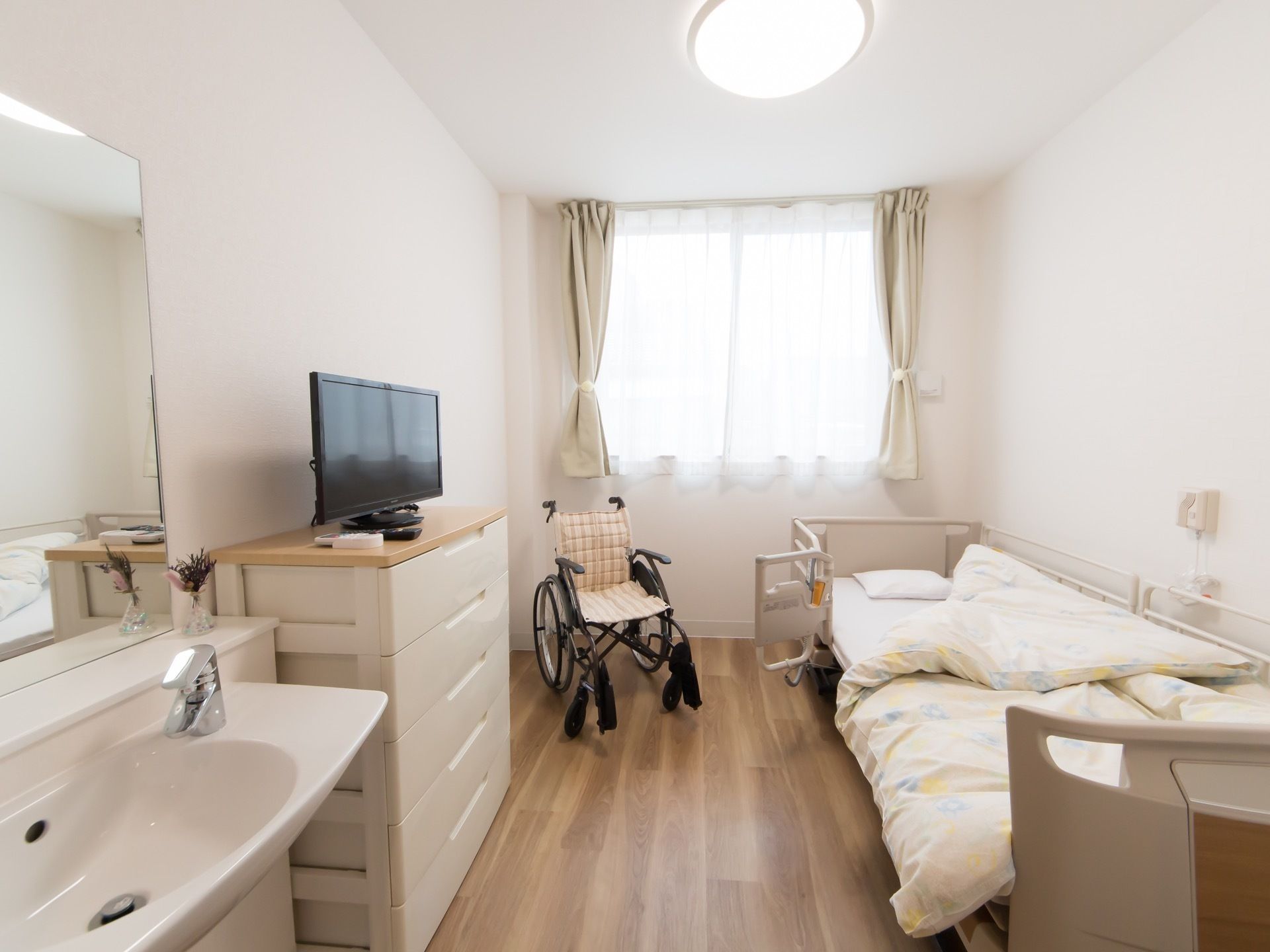 部屋の突き当たりは全面腰高窓になっており、部屋全体に外光が入る。介護用ベッドと緊急通報ボタンが備え付けられている。