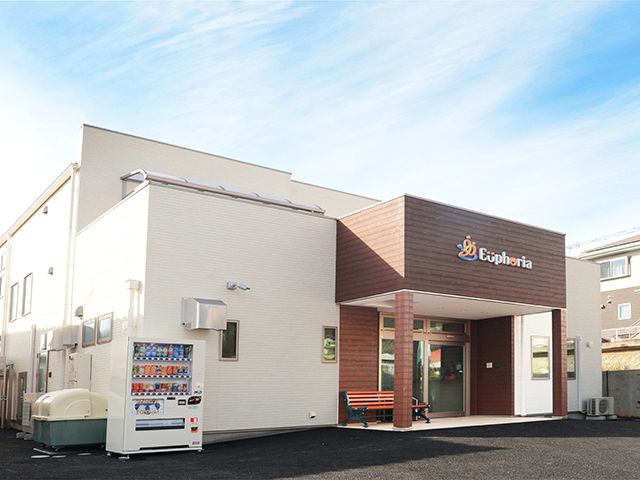 白を基調とした建物の玄関部分はブラウンで車寄せが付き、ホーム名が書かれている。玄関の横にはベンチがあり、自動販売機も設置されている。