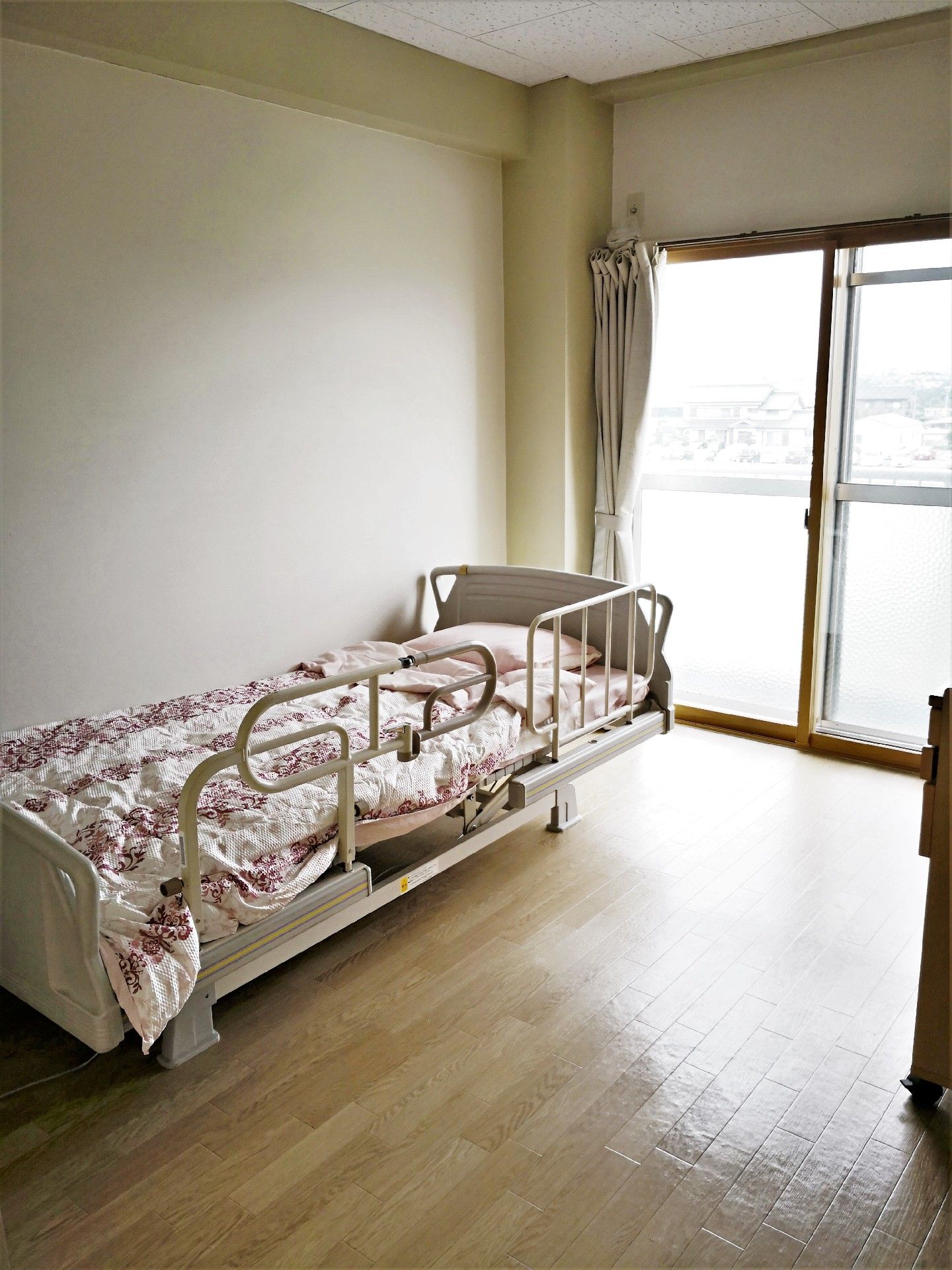 大きな窓があり明るい雰囲気。居室には、寝具付きベッドやエアコンもついている。
