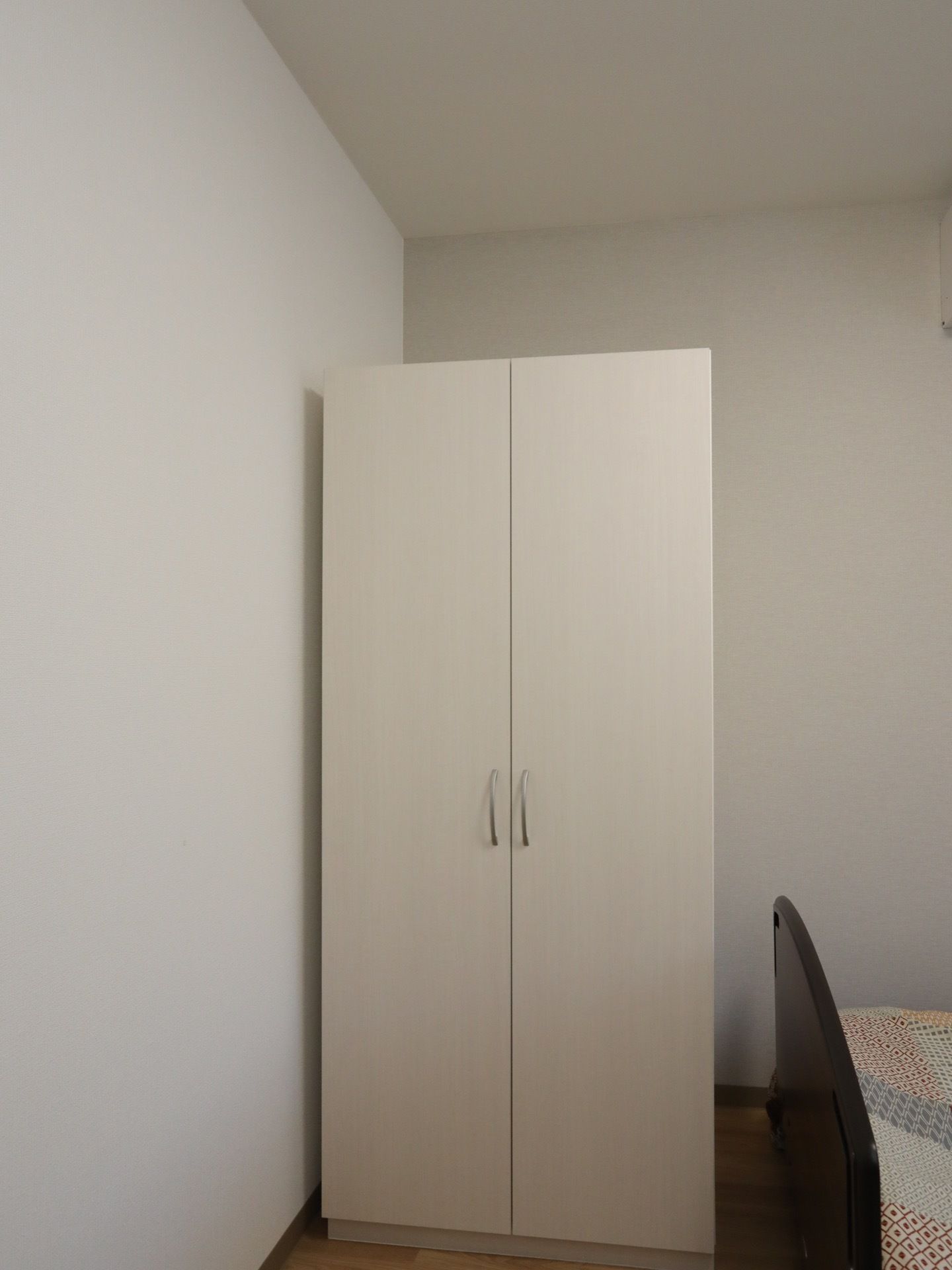 白を基調とした明るく清潔感のある居室である。真っ白な洋服ダンスや介護用ベッドが完備されている。床は板の間である。