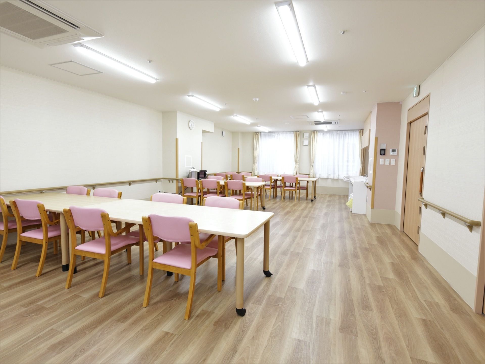 食堂には白のダイニングテーブルとピンクの椅子がある。。スペースはとても広く、ゆとりある動線が確保されている。