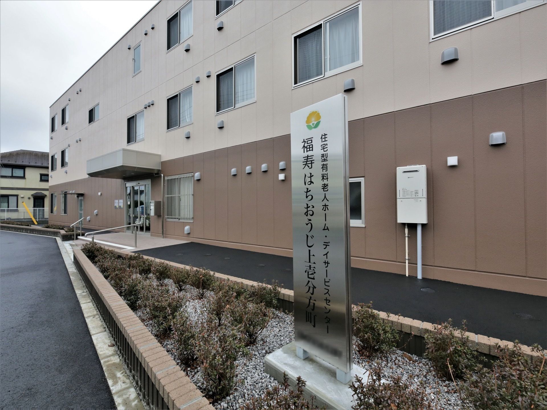 施設は３階建で道路沿いに建てられている。ダークブラウンとベージュのコントラストが落ち着いた雰囲気の外観になっている。