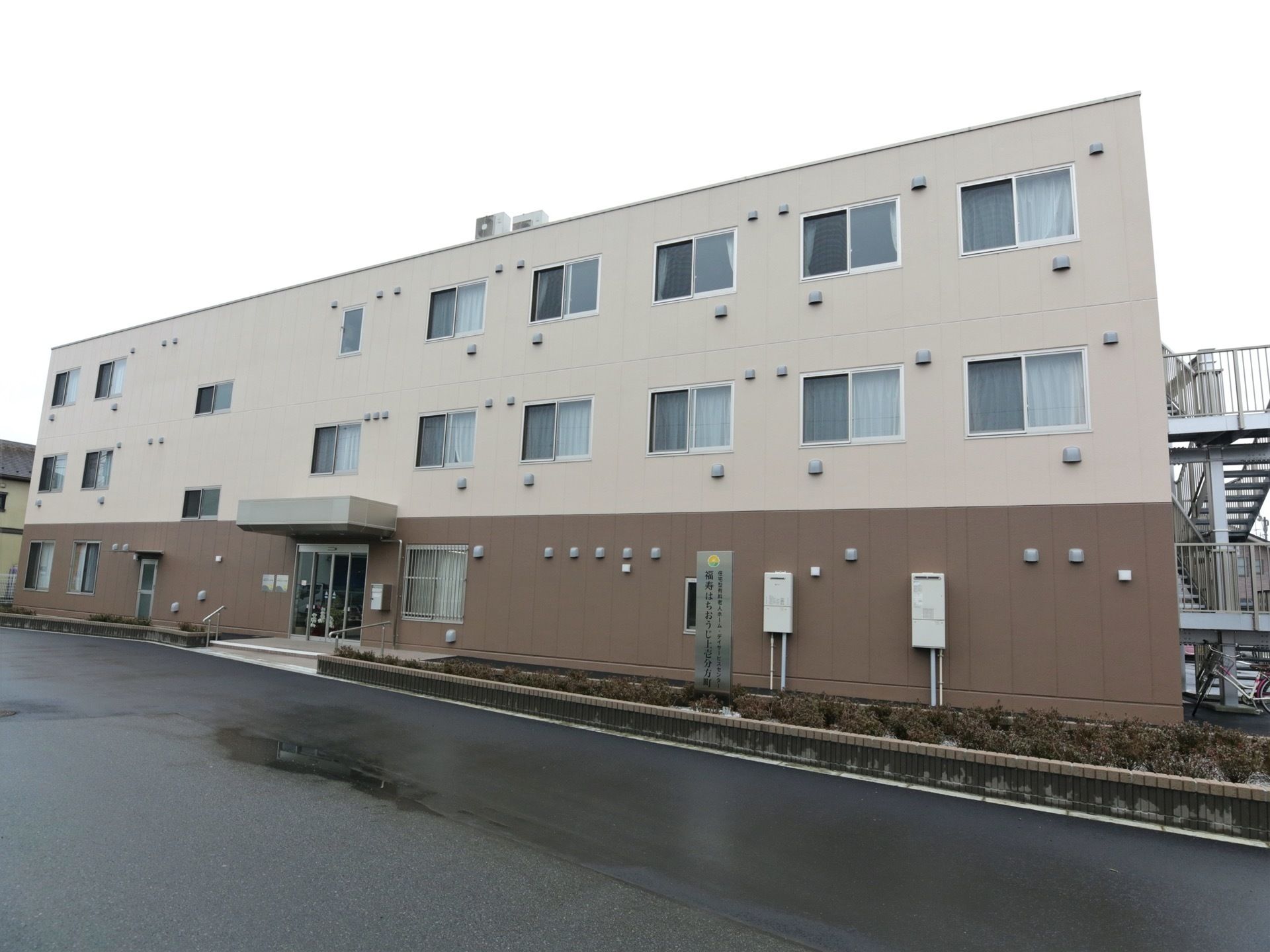 施設は外壁にブラウン系を採用し、スッキリとした雰囲気になっている。広い道路に面して立地していおり、入り口は自動ドアになっている。