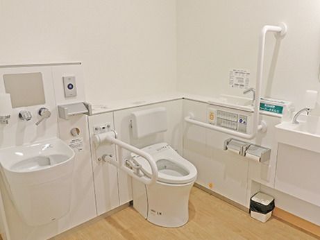 オストメイト対応のトイレには手すりや背もたれがあり、オレンジの呼び出しボタンもある。