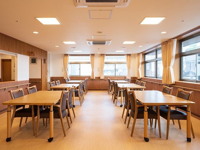 4人掛けのダイニングテーブルが複数並んだ広い食堂にはたくさんの窓が付いている。