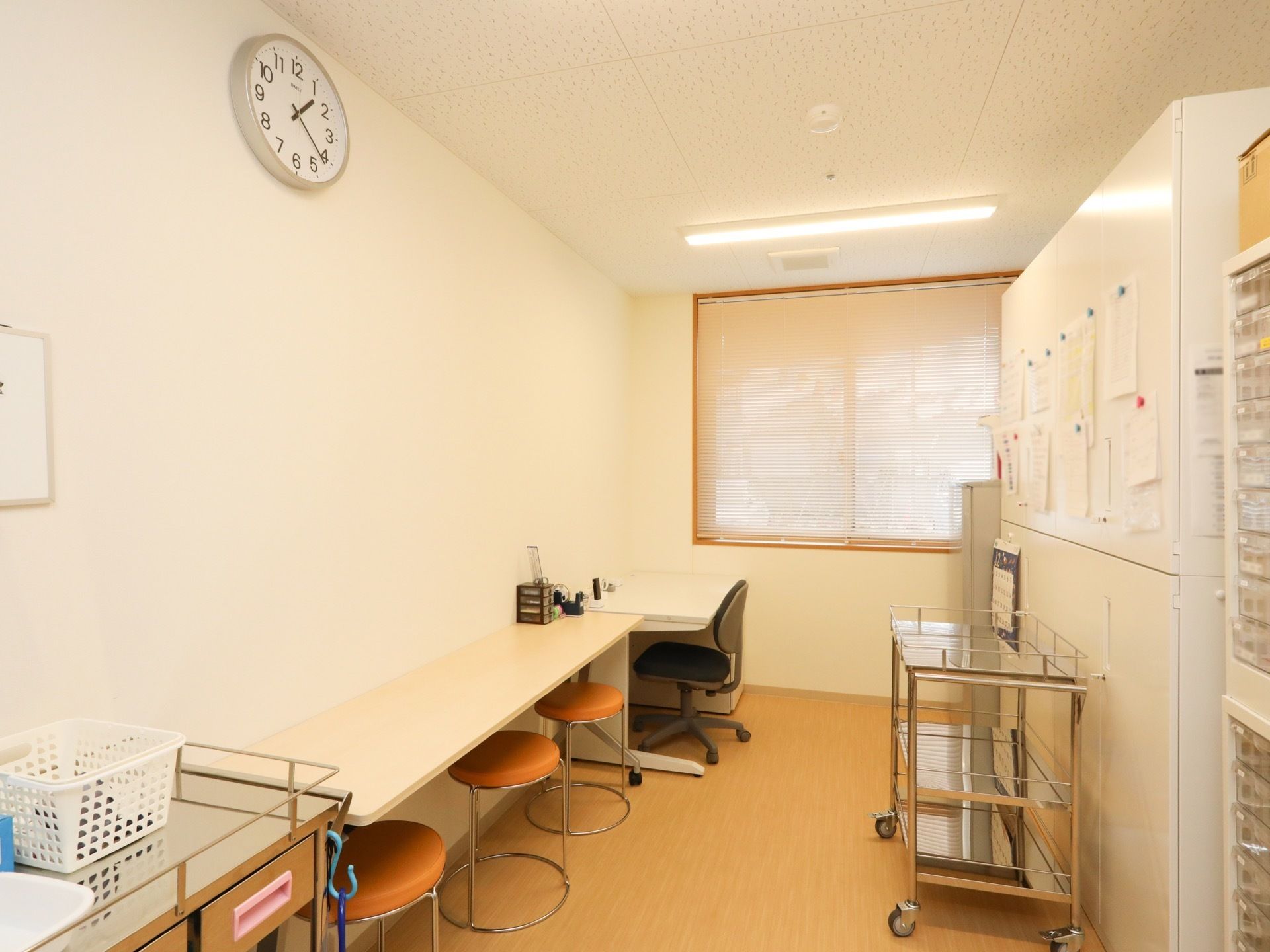 明るく落ち着いた雰囲気の健康管理室である。キャビネットと薬棚が設置されており、スチールワゴンが置かれている。