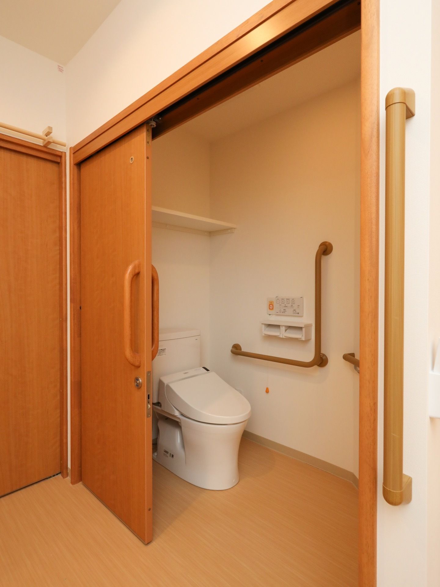 居室には、車椅子対応トイレが備わっている。L型手すりや温水洗浄便座、呼び出しボタンといった設備が完備されている。