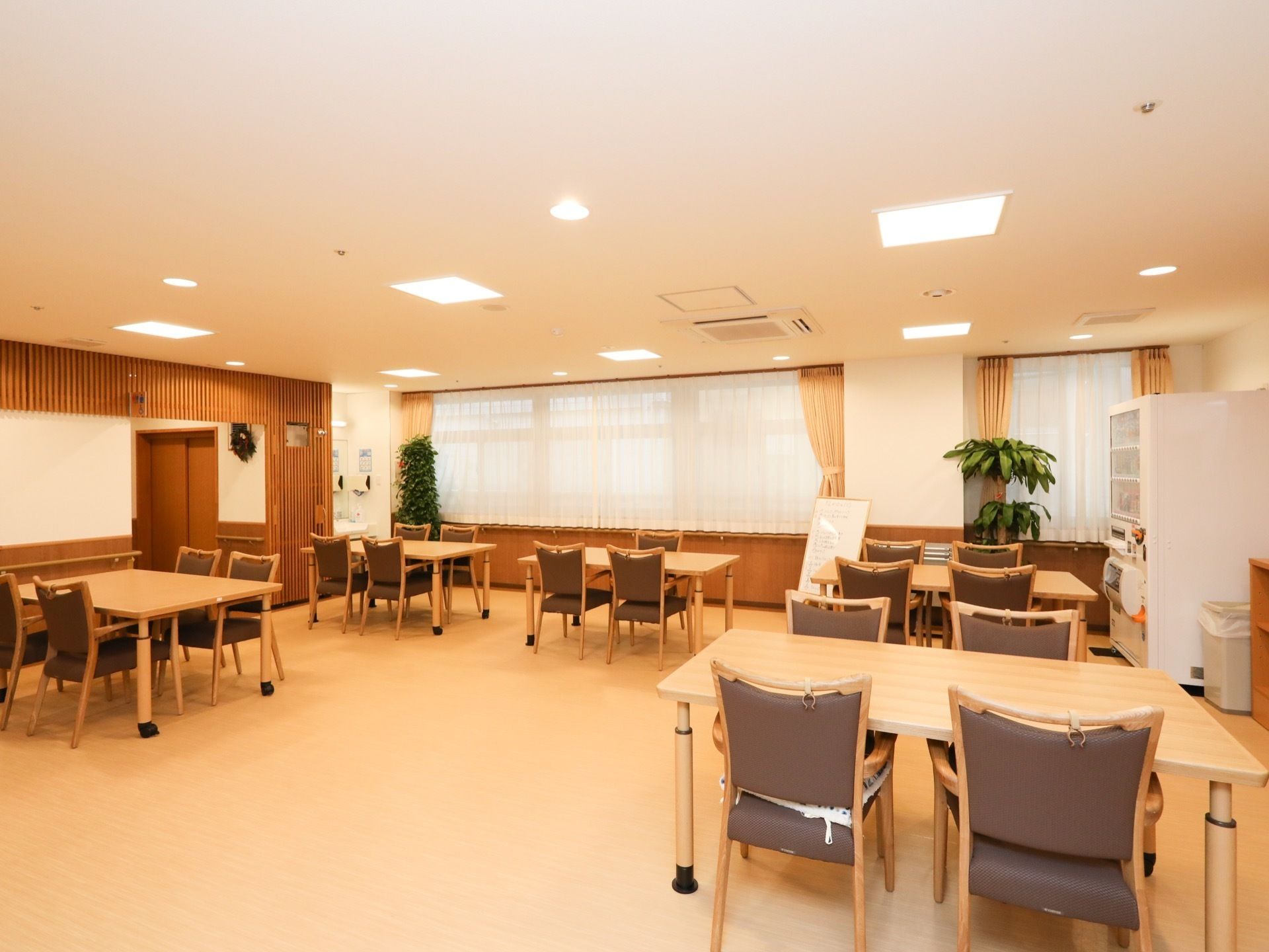 食堂は明るく落ち着いた雰囲気の空間になっている。４人掛けテーブルが用意されており、壁際に自販機が設置されている。