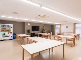 空調設備が整っているリビングで、天井には複数の蛍光灯が設置されている。床はフローリングとなっている。