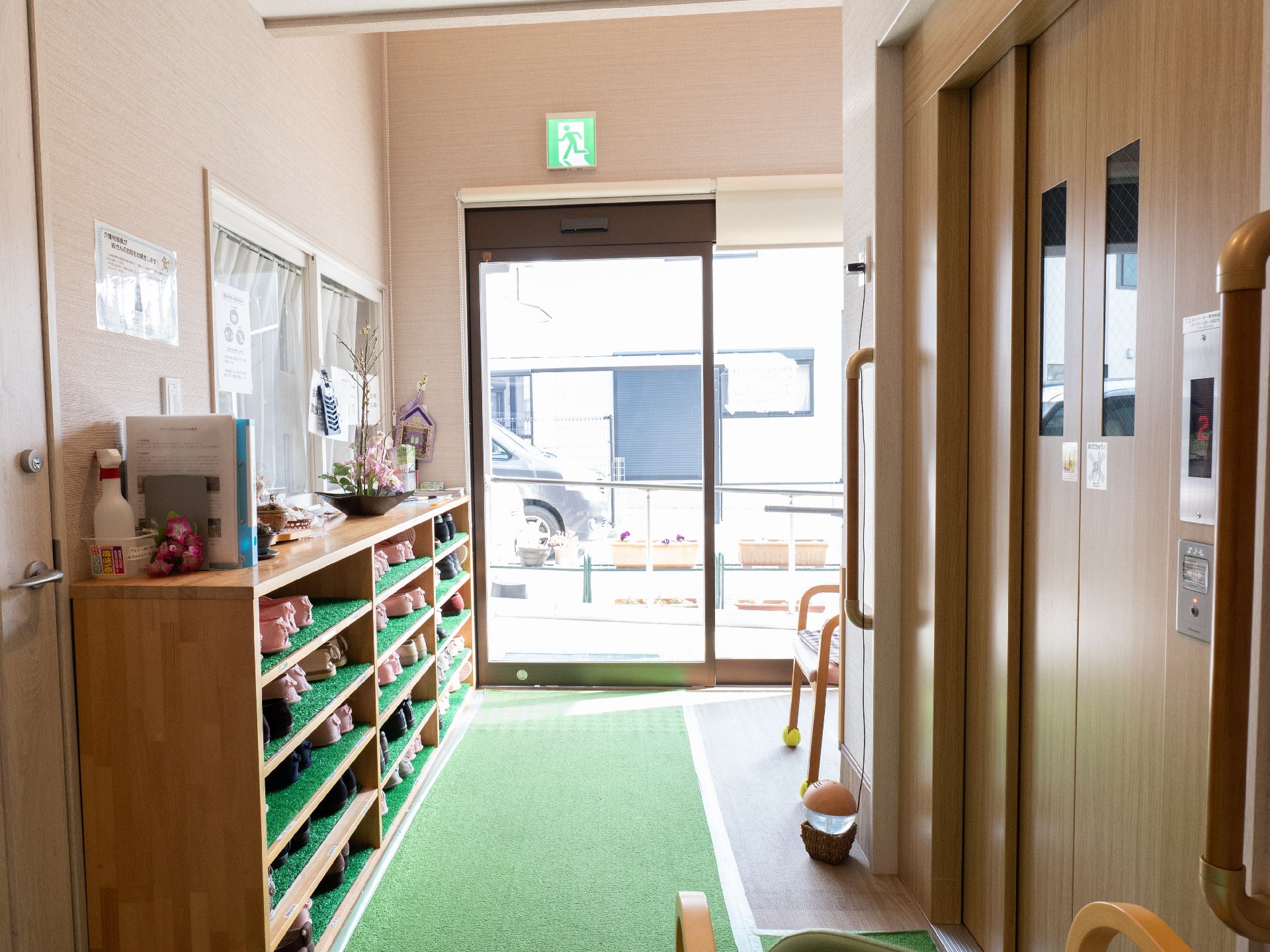 なにかを指さして笑顔で話している車いすの女性とそれを押している介護スタッフの様子