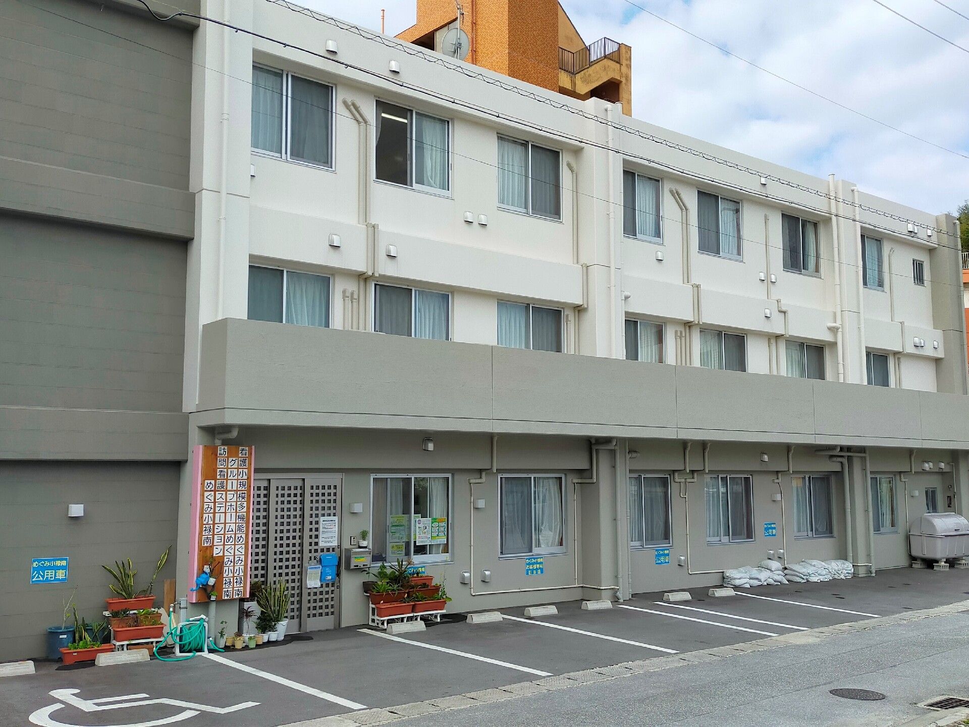 なにかを指さして笑顔で話している車いすの女性とそれを押している介護スタッフの様子