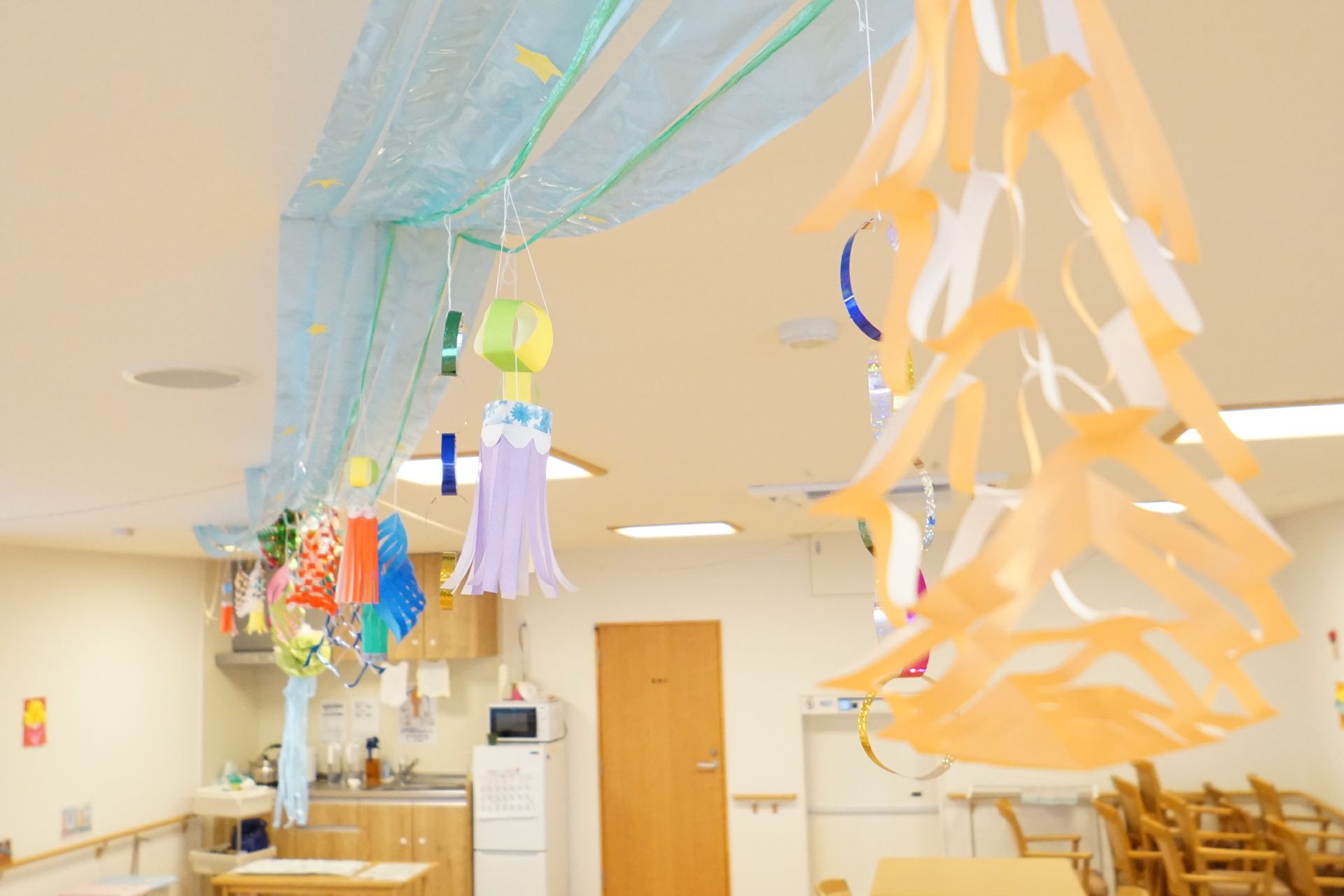 紙で作られた飾りが吊るされている大きな部屋の天井