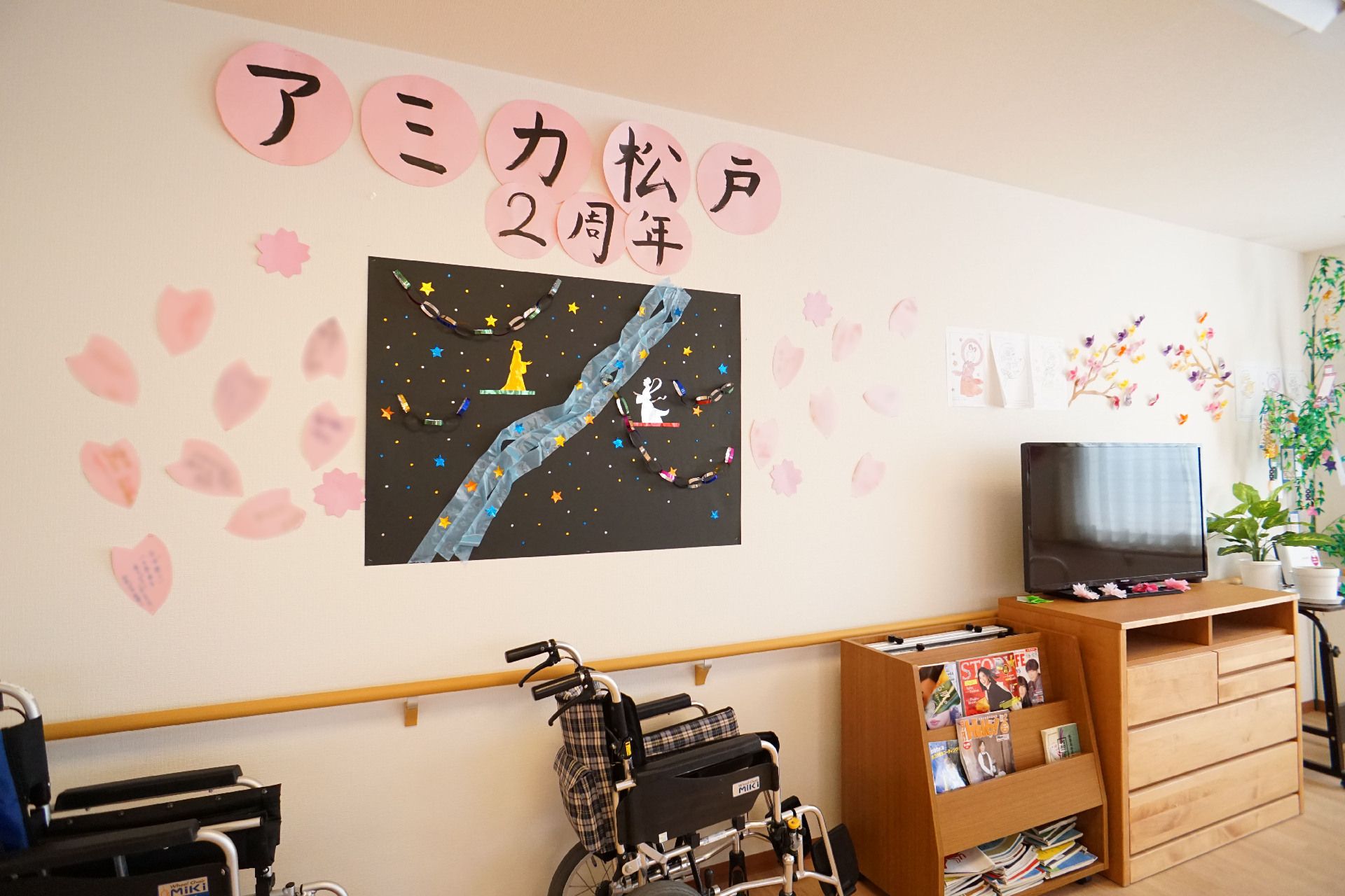 車いすが置かれた部屋の壁一面に貼られた紙