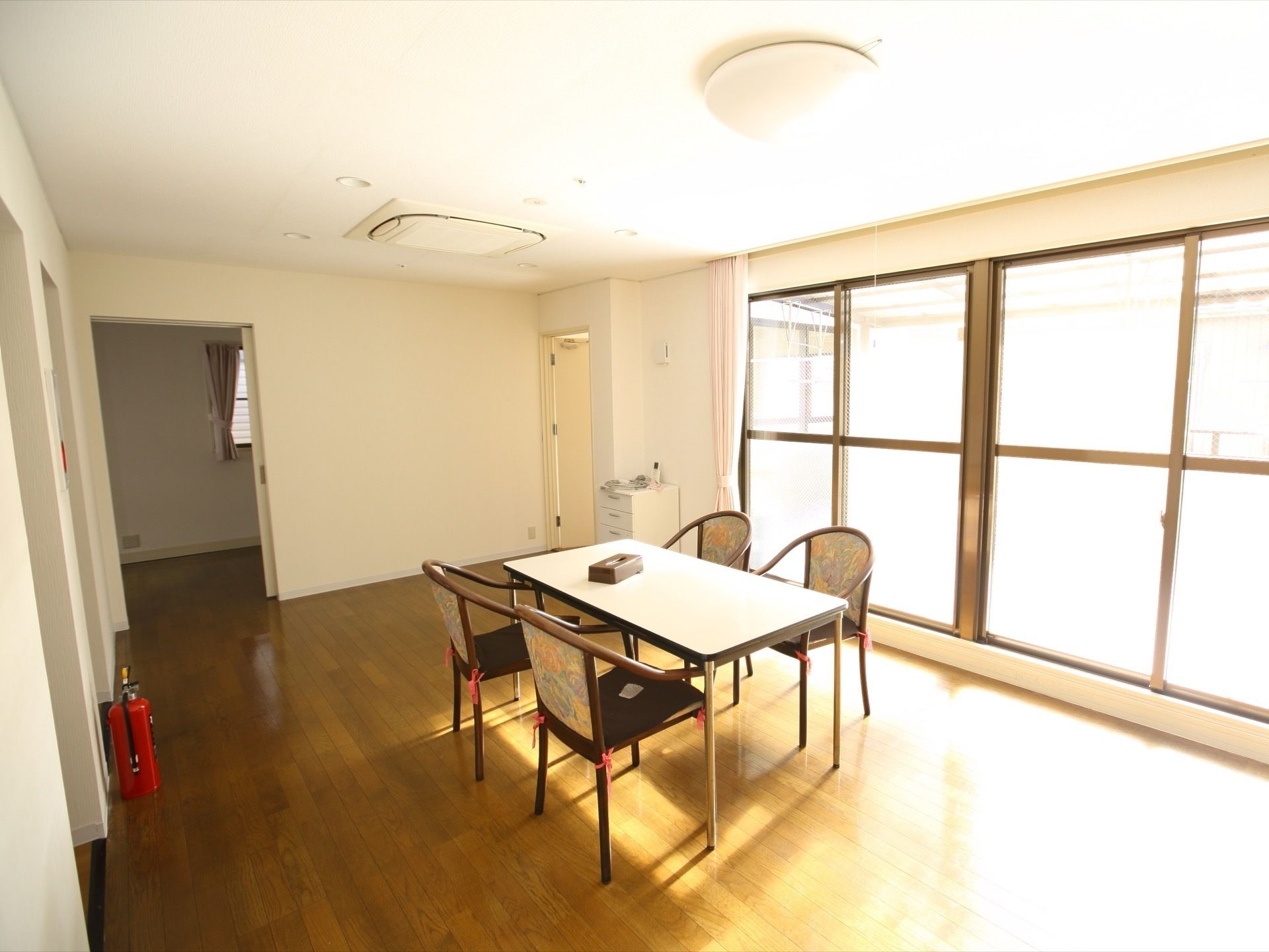 ベランダへと通じるドアからは、部屋へと明るい光が差し込んでくる。シンプルな造りであるため、穏やかに談話に勤しむことが可能となっている。