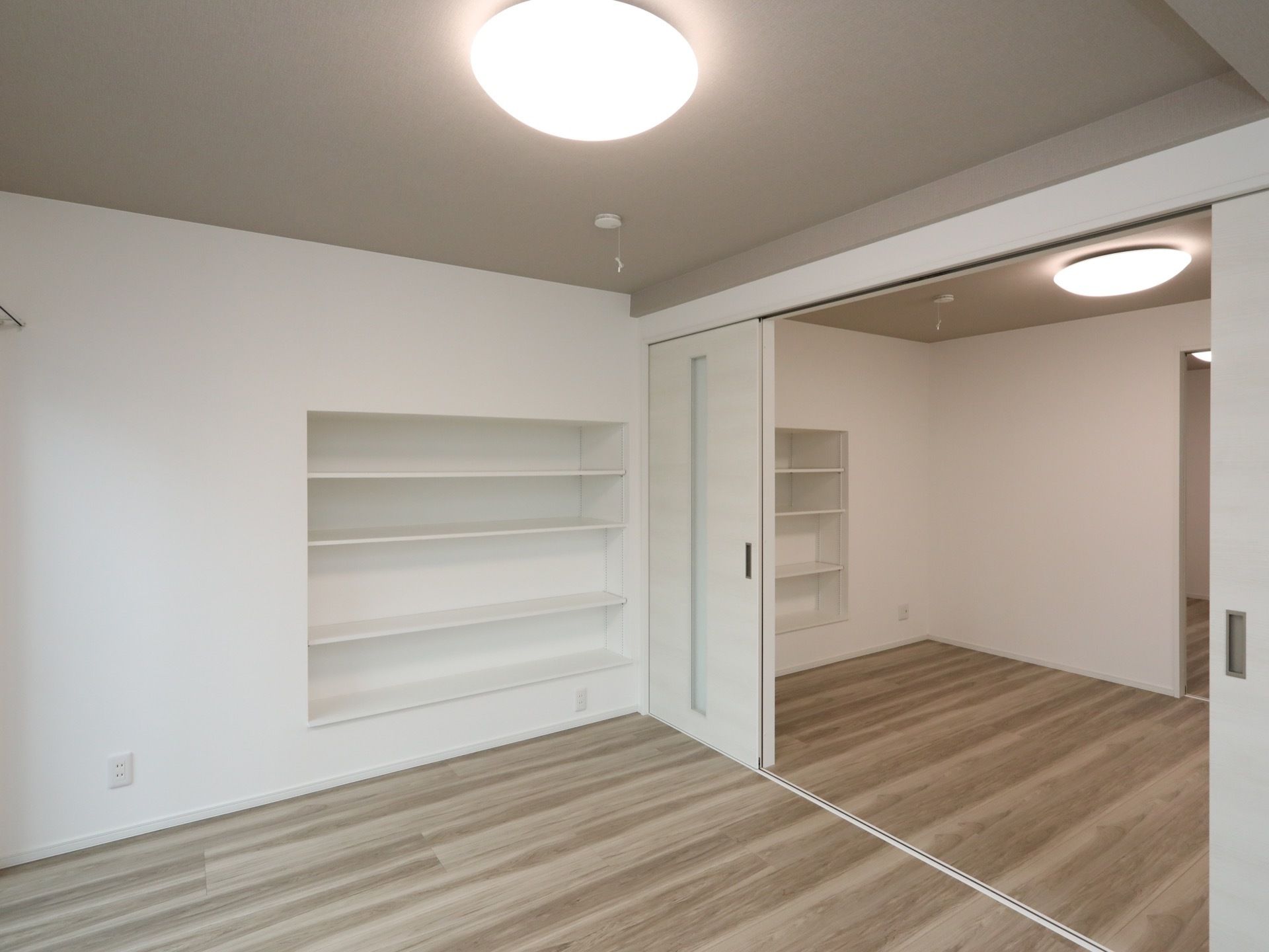 居室は仕切ることができ、どちらの部屋にも備え付けのオープンシェルフがある。ドアは引き戸で開閉しやすい。
