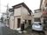 施設の外壁は茶色い色味で、２階建ての建物となっている。玄関には、シルバーの取っ手がついた木目調の扉が取りつけられている。