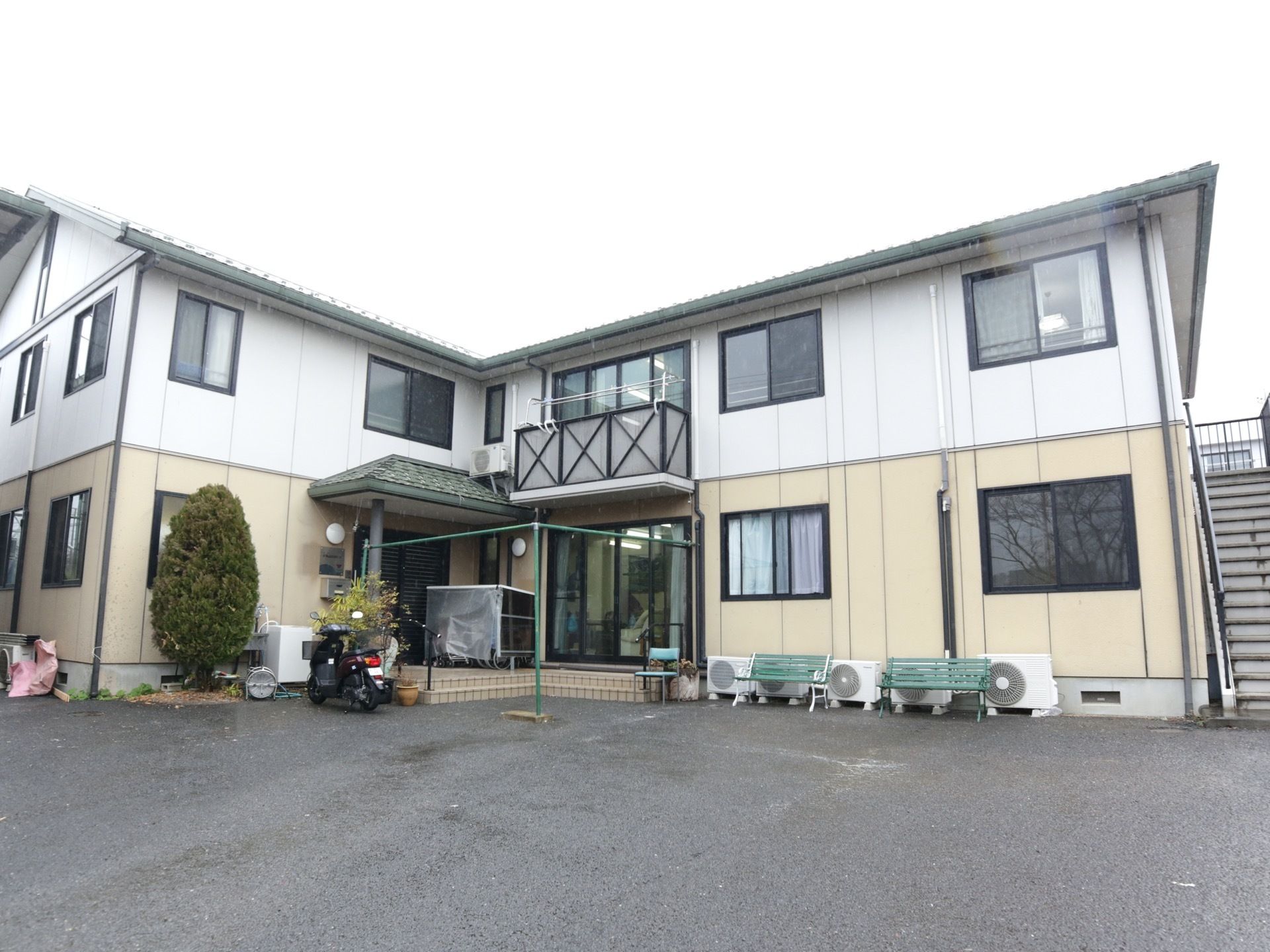 ツートンカラーの外壁を持つ２階建ての施設である。玄関近くの建物の近くに緑路のベンチが２つ並べて置かれている