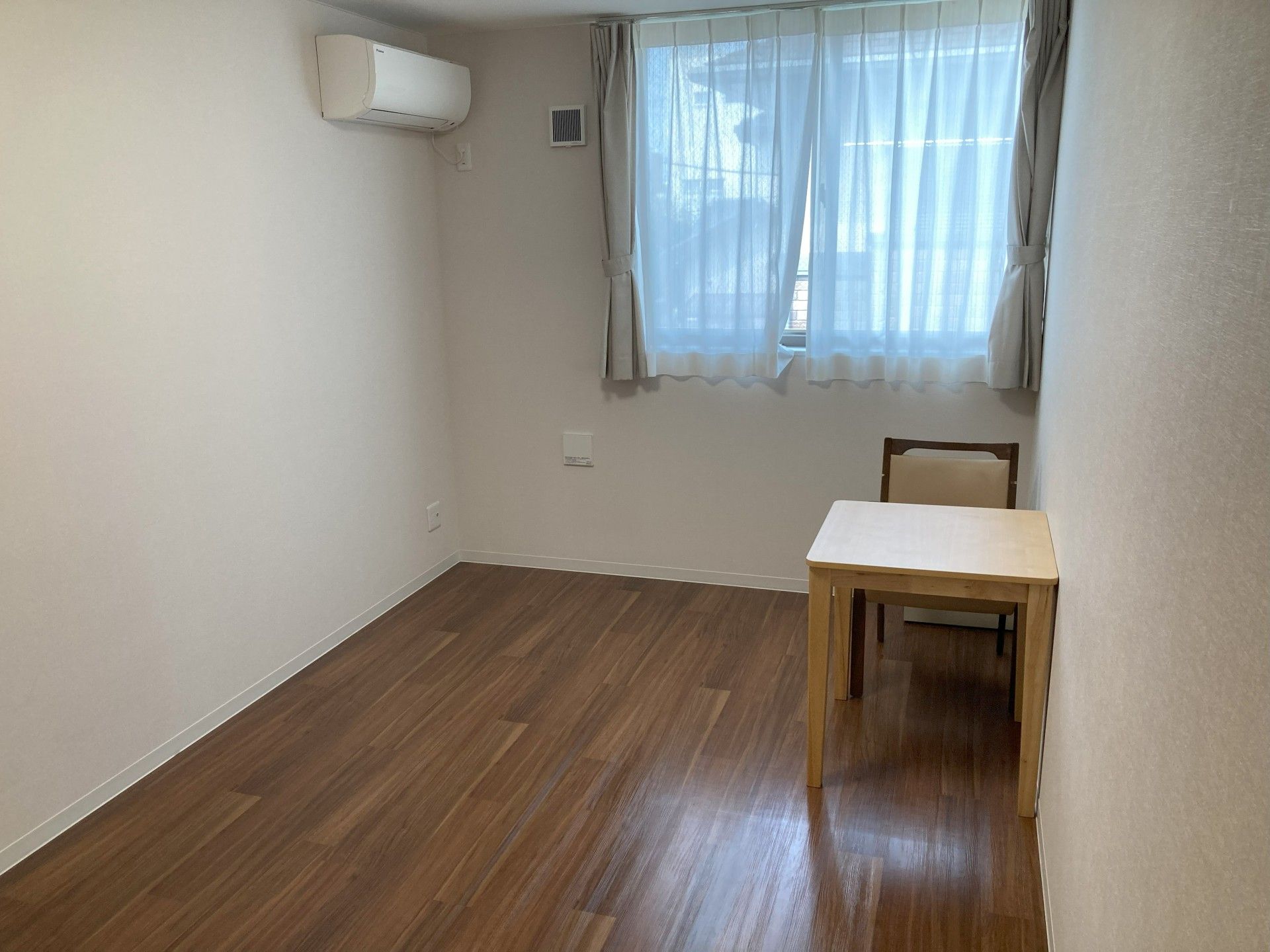 フローリングの個室にはエアコンが完備され、部屋の隅には避難用の梯子がセットされた箱もある。