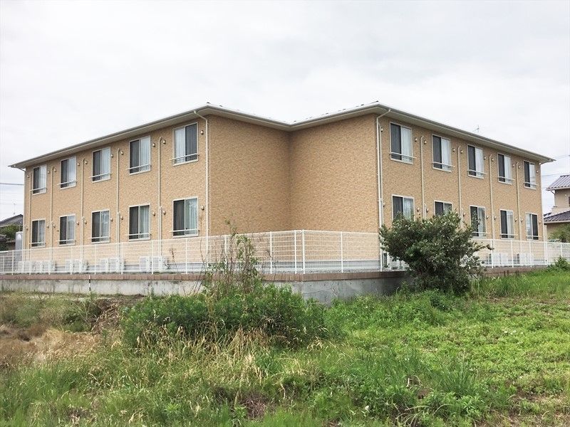 周辺を緑に囲まれた施設の外観写真。２階建ての鉄骨造の建物