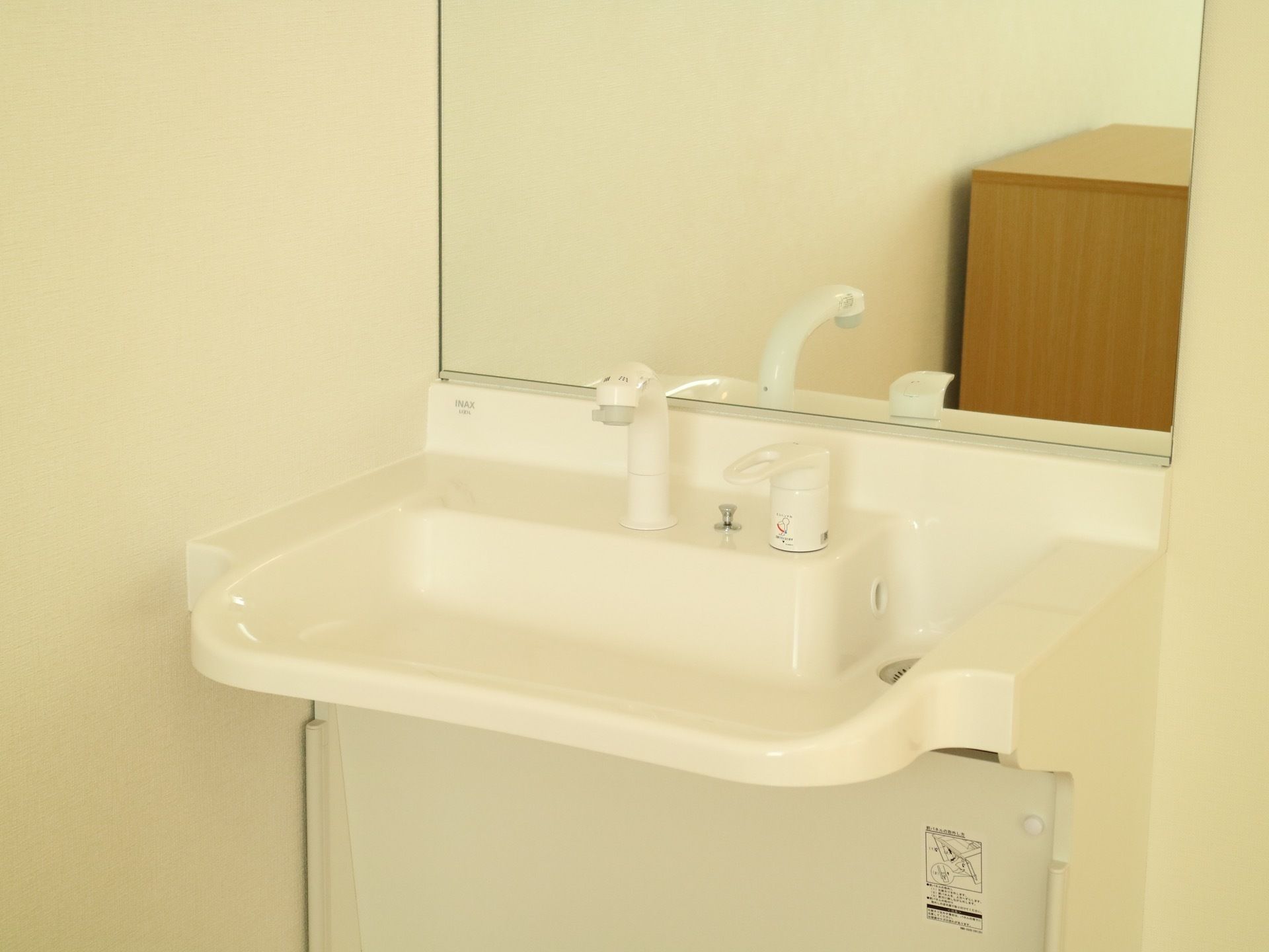 居室には車椅子対応の鏡付き洗面台を設置している。上下に動かして水道の開栓を行うタイプの蛇口は、使用しやすく便利である。