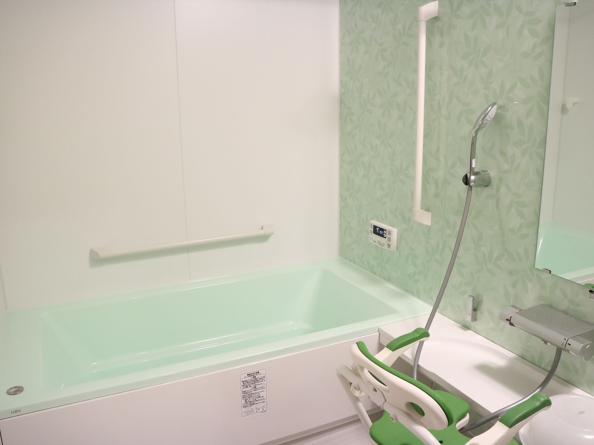 背もたれ付きのシャワーチェアや手すりが設置された一人用の浴室