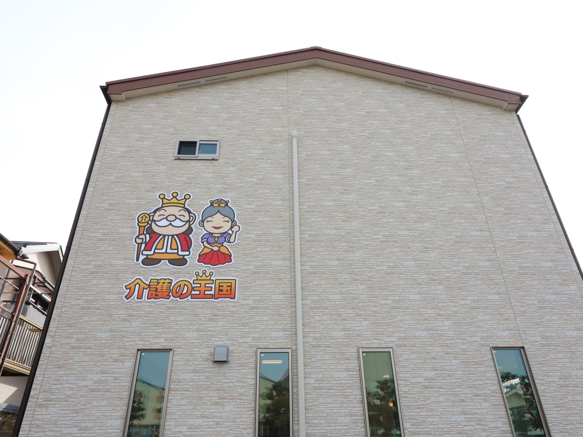 建物外壁はベージュ系である。２階の外壁に大きく施設のシンボルマークの絵と施設名が書かれていて、遠くからでも確認できる。