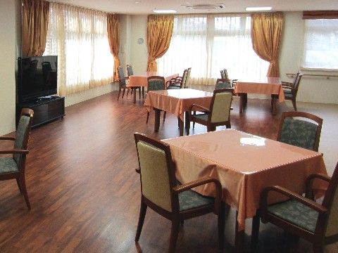 ４人掛けのテーブルが並べられており、薄いピンク色のテーブルクロスが掛かっている。カーテンは綺麗な黄色でおしゃれである。