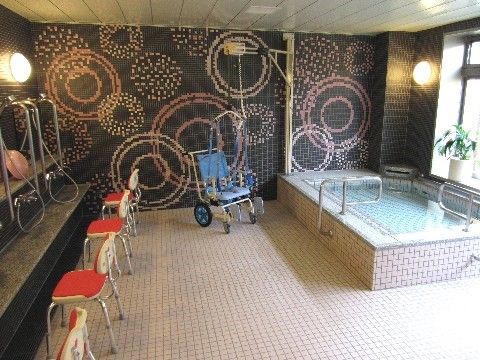 壁は黒く花火の模様がデザインされており、明るい気持ちにさせてくれる。浴槽の側には観葉植物が置いてある。