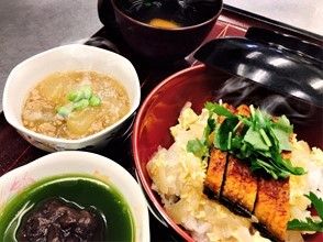 黒い盆の上には丼ものやそぼろあんかけ、汁物などが置かれている。