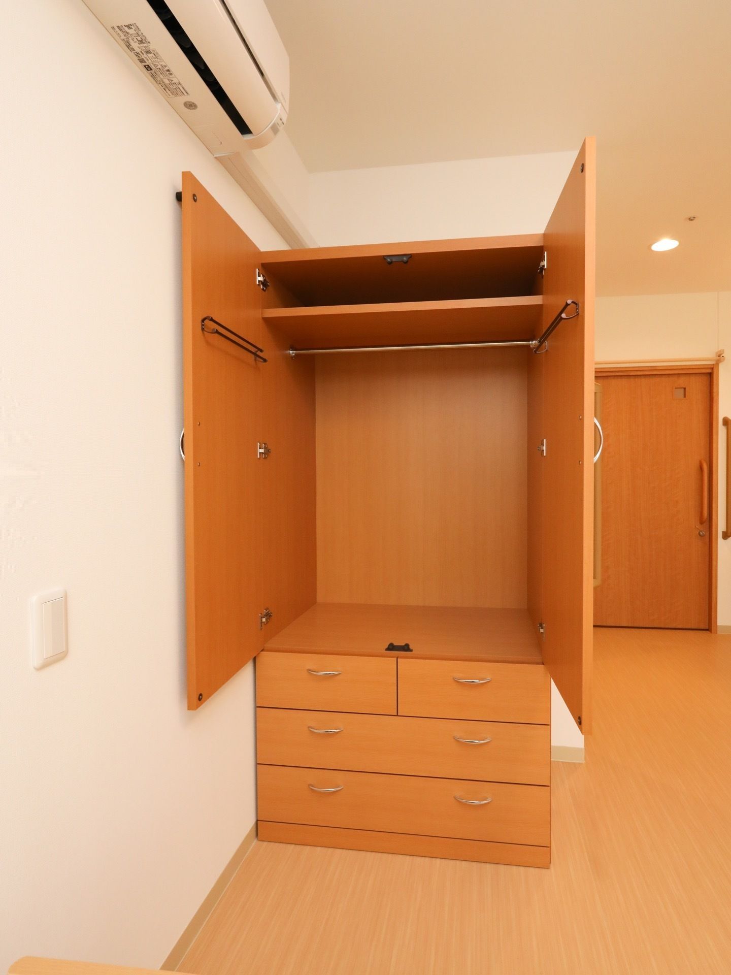 エアコンが完備されているワンルームの居室である。クローゼットが用意されており、内部にハンガーポールが設置されている。