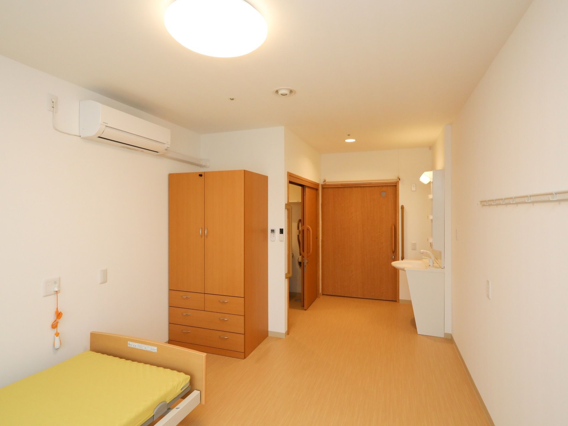 エアコンやナースコールが完備されているワンルームの居室で、トイレや洗面台も備え付けられている。床は、フローリングが採用されている。
