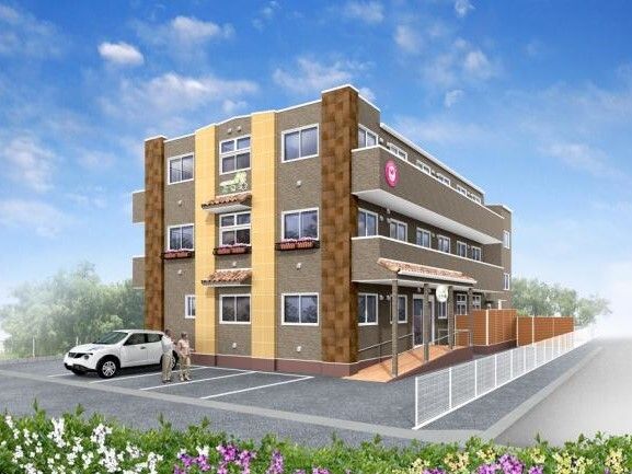 各フロアにベランダがあり、ブラウン系の外壁の3階建ての建物。敷地内には駐車場があり、玄関からもスムーズに行くことができる。