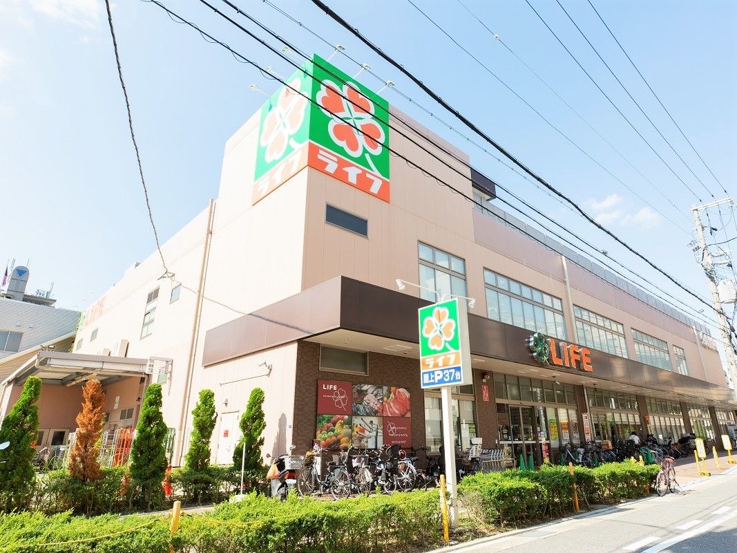 ライフの看板がある建物の外観。鉄骨造２階建ての建物を晴れた日に写した写真