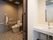 手すりや呼び出しボタンが設置されたトイレは引き戸で、洗面所には大きな鏡がある。
