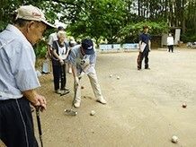 車椅子に乗った高齢女性を介助する女性ヘルパー
