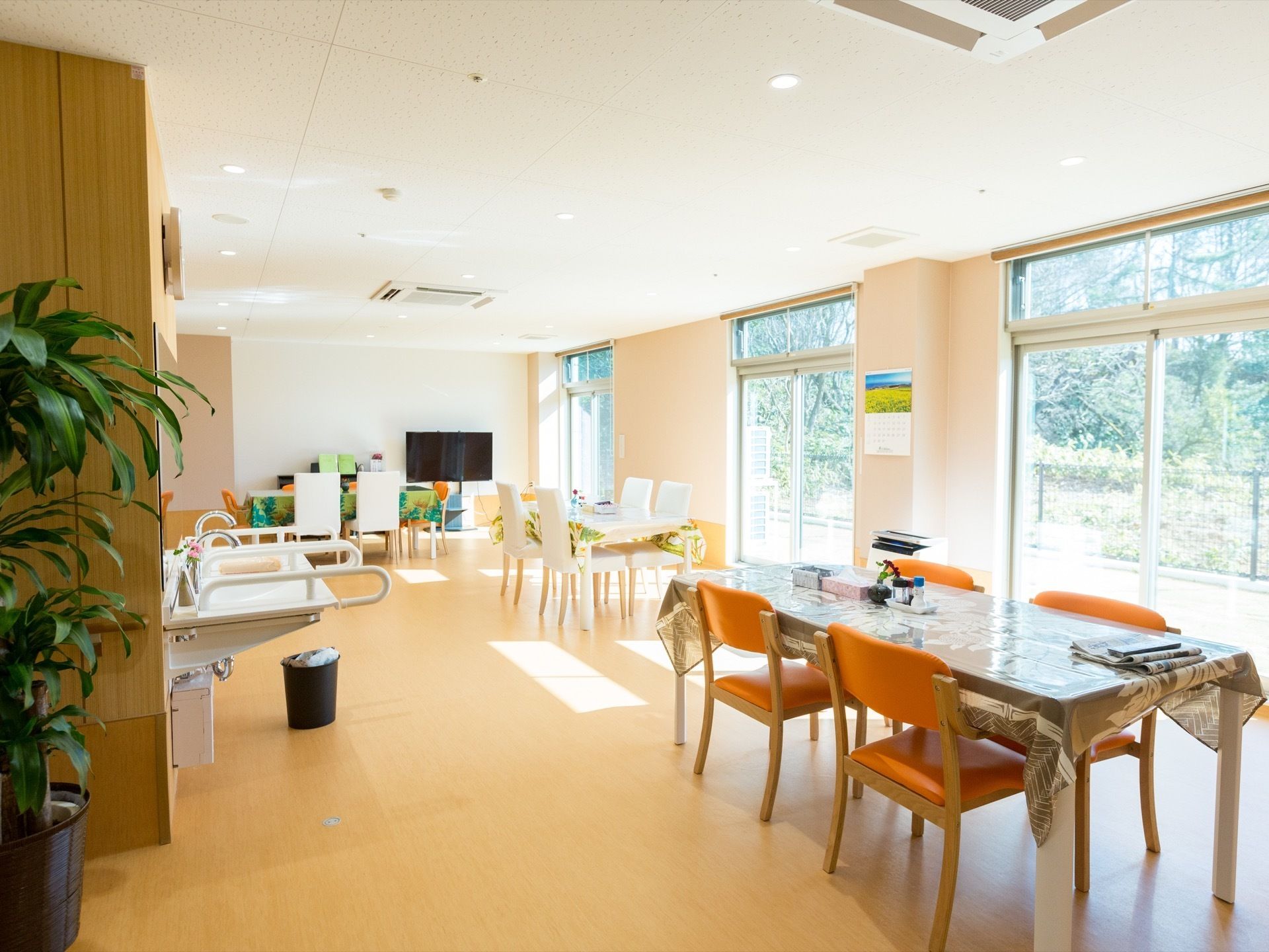 日当たりが良い、開放的な空間である。テーブルにはテーブルクロスが掛けられており、新聞が用意されている。